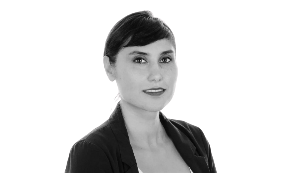 Portrait de Nassime Zafarsani, souriante en tenue professionnelle, sur fond blanc