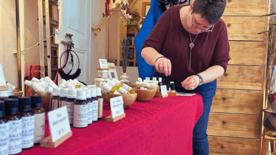 stella noverraz installant des produits d’aromathérapie Mini-Druide sur un stand