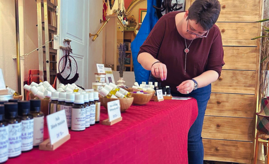 stella noverraz installant des produits d’aromathérapie Mini-Druide sur un stand