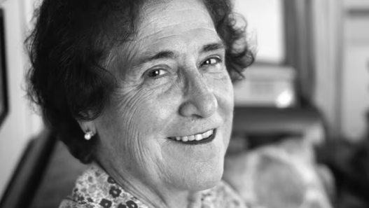 Portrait en noir et blanc de Emilie Lieberherr souriante, photographiée en intérieur.