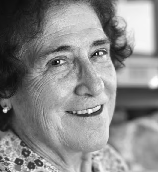 Portrait en noir et blanc de Emilie Lieberherr souriante, photographiée en intérieur.