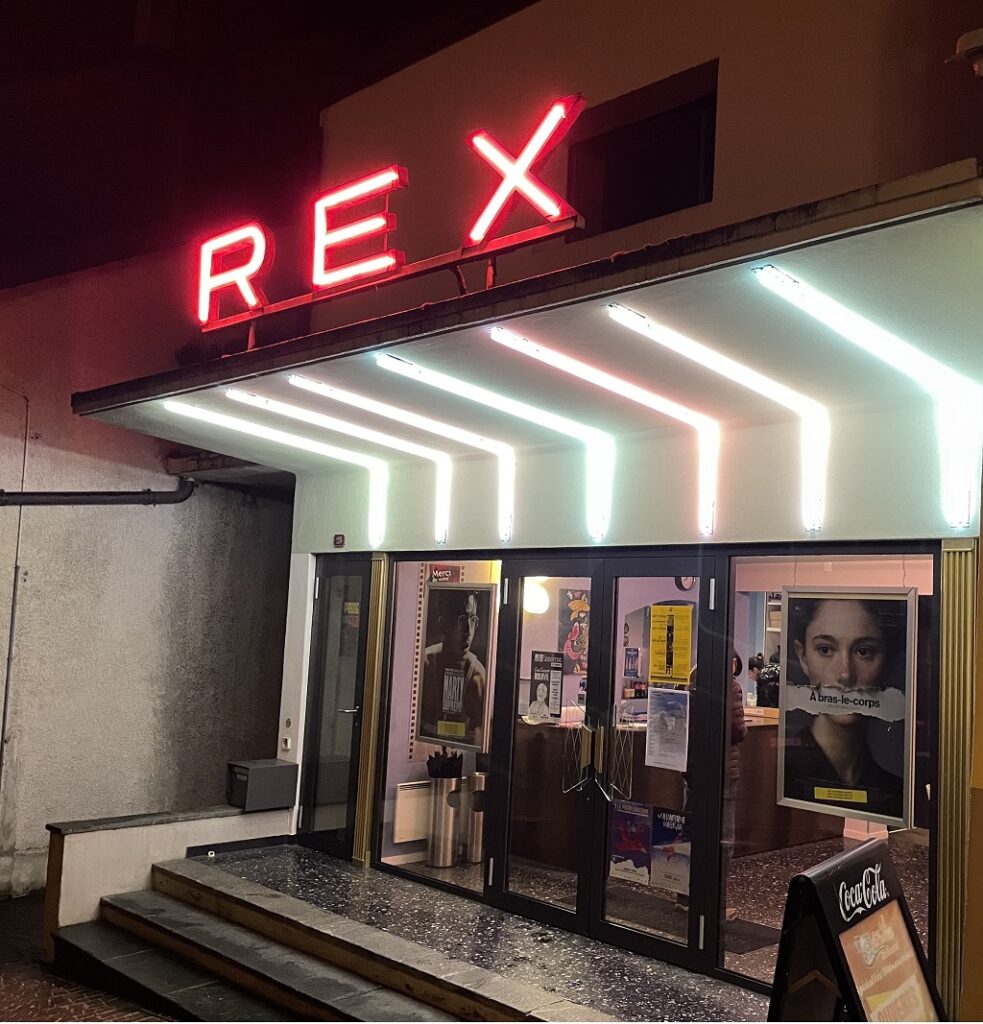 Façade illuminée du Cinéma REX à Aubonne de nuit, avec l’affiche du film suisse À bras-le-corps (Silent Rebellion) visible à l’entrée, le 17 février 2026.