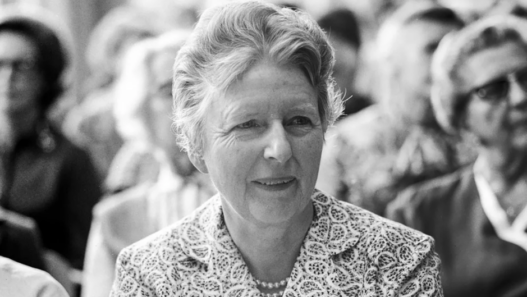 Gertrud Heinzelmann assise parmi d’autres femmes lors d’une réunion, photo en noir et blanc.