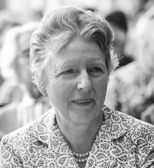 Gertrud Heinzelmann assise parmi d’autres femmes lors d’une réunion, photo en noir et blanc.