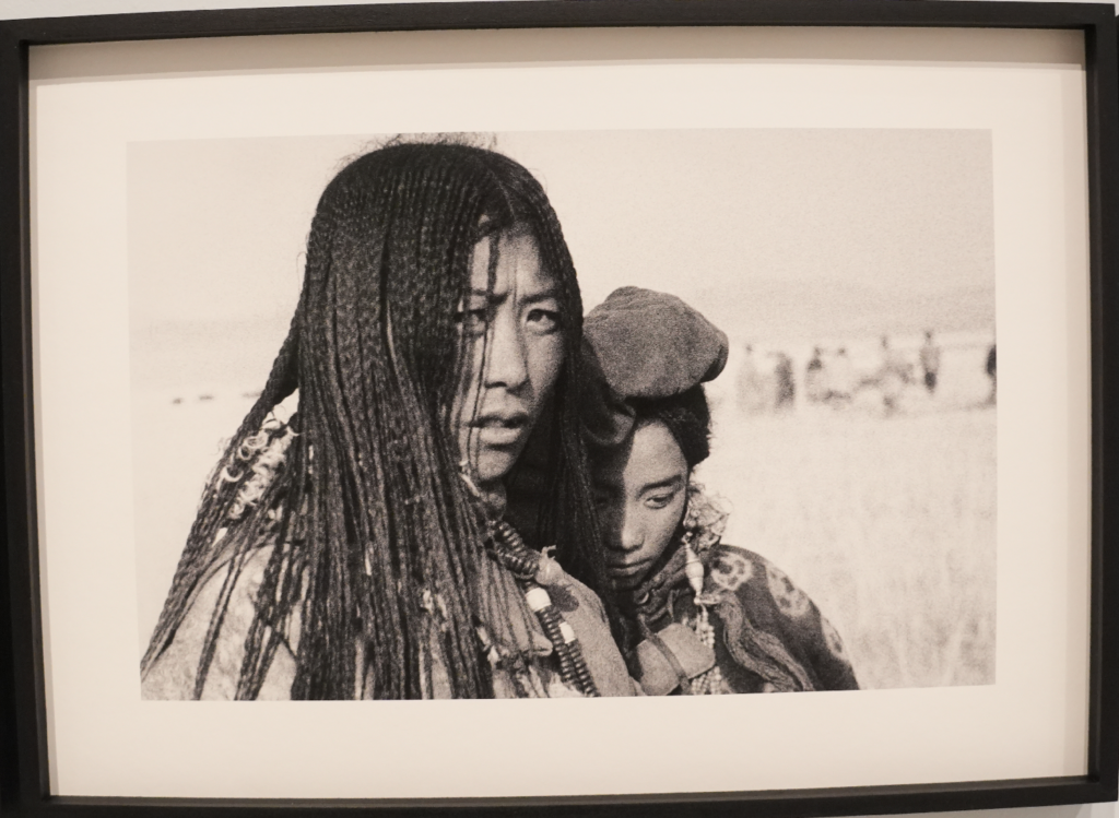 Photographie en noir et blanc encadrée montrant deux femmes tibétaines aux longues tresses, réalisée par Ella Maillart