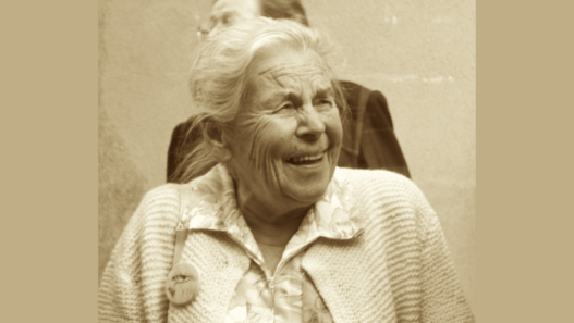Elisabeth Pletscher souriante, militante suisse du suffrage féminin et pionnière des sciences de laboratoire, photographiée à un âge avancé