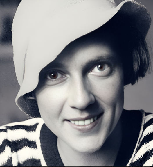 Portrait en noir et blanc d’Ella Maillart jeune, souriante, portant un chapeau clair et un pull rayé