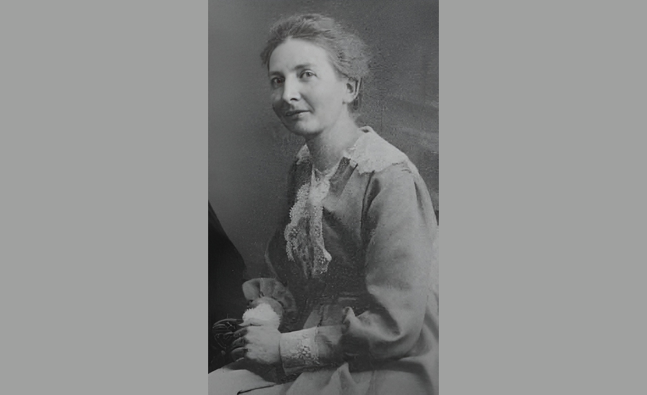 Portrait d’Hélène Monastier, enseignante vaudoise et figure du pacifisme en Suisse romande, assise en robe claire, début du XXe siècle.