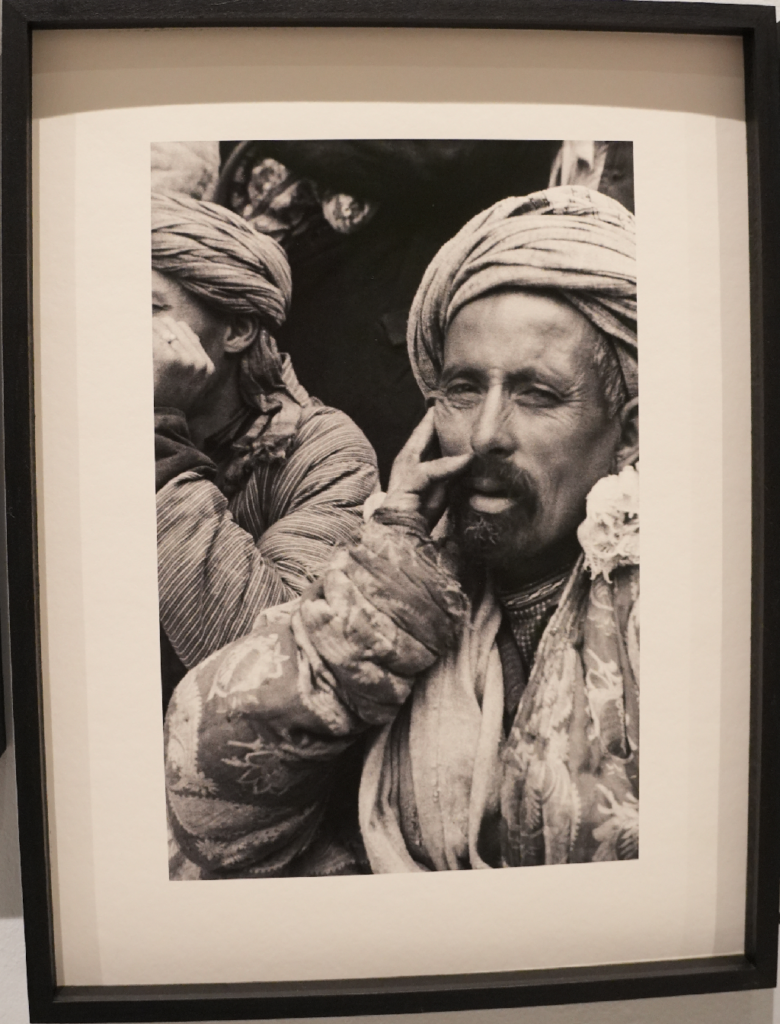 Photographie en noir et blanc encadrée montrant un homme en turban et un autre personnage en arrière-plan, réalisée par Ella Maillart