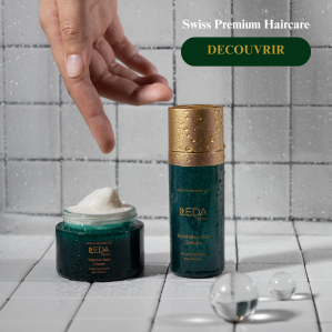 Une main pointe vers deux produits capillaires vert et or posés sur un carrelage blanc, un pot ouvert rempli de crème et un flacon, avec le texte Swiss Premium Haircare et un bouton vert DECouvrir au-dessus.