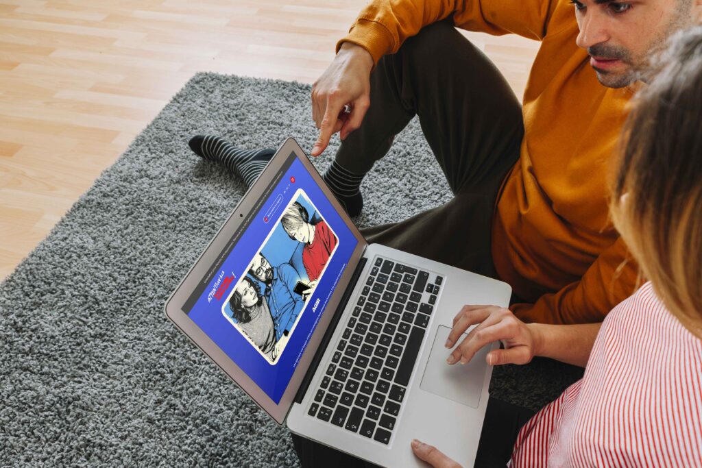 Adulte accompagnant un adolescent devant un ordinateur portable affichant un contenu sur la manosphère, illustrant le dialogue et la prévention face aux discours masculinistes en ligne