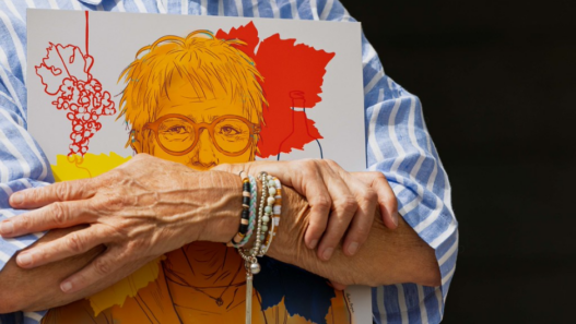 Personne tenant une illustration colorée d’un portrait féminin, créée pour les 30 ans de la loi sur l’égalité en Valais.