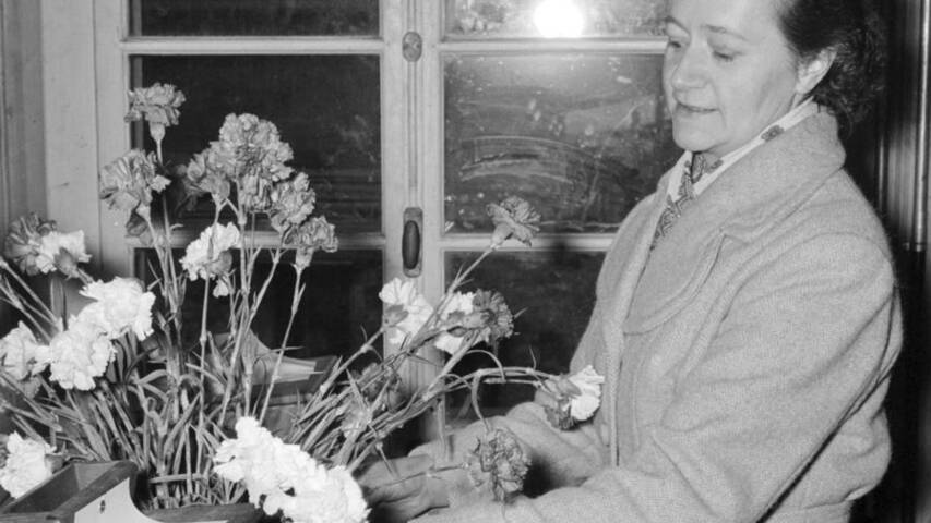 Katharina Zenhäusern place des fleurs près des urnes de vote réservées aux femmes à Unterbäch, le 3 mars 1957.