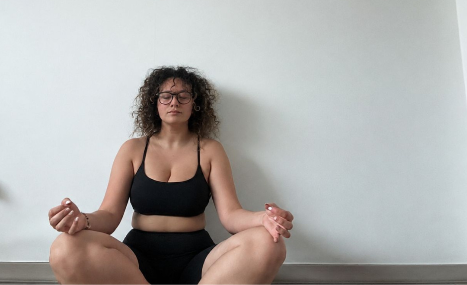 Femme assise au sol les yeux fermés pendant une session de cohérence cardiaque, en posture calme et confortable.