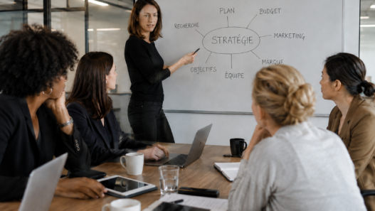 Femmes en réunion professionnelle échangeant autour d’une stratégie, illustration de la sororité en entreprise et du soutien entre collègues.