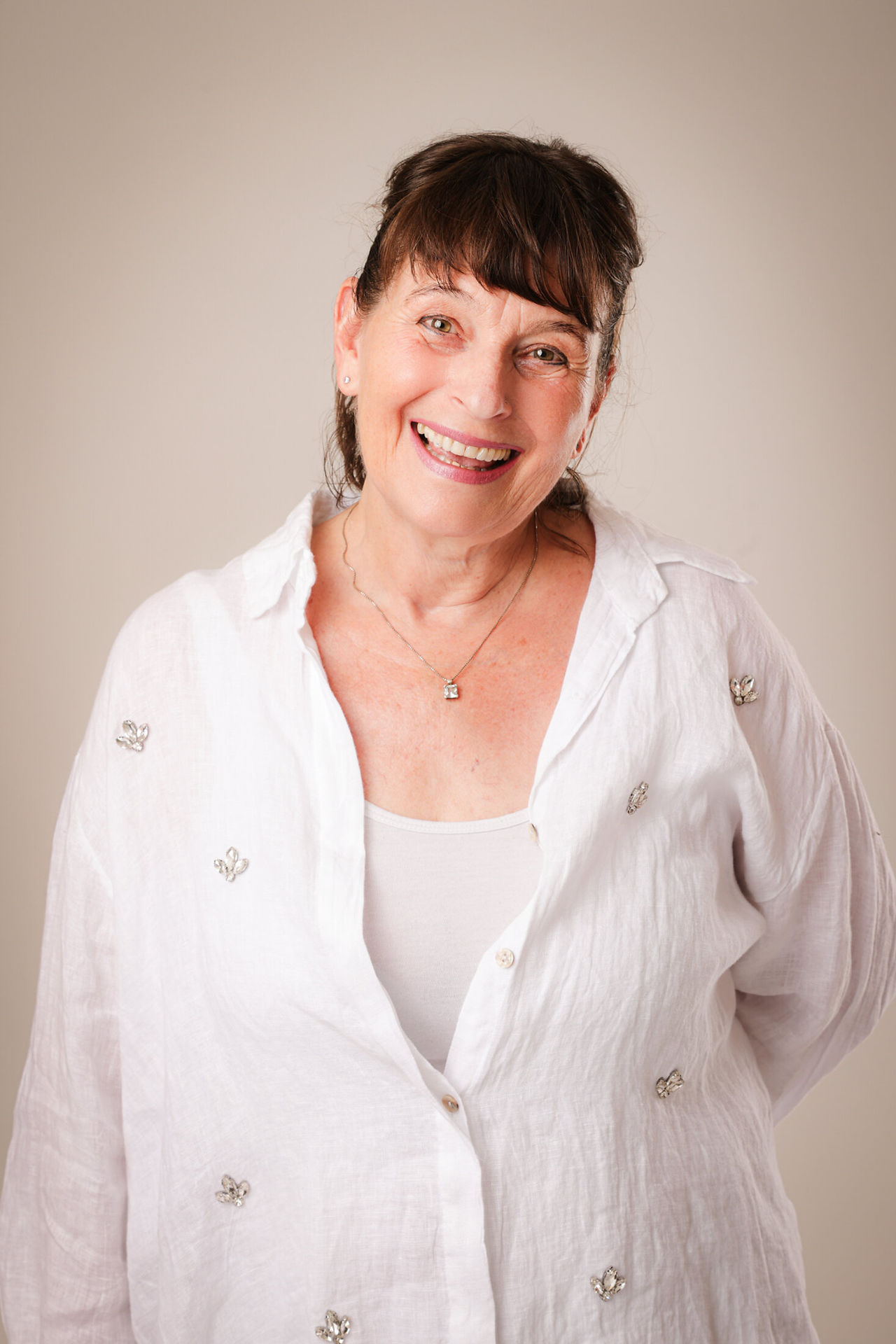 Portrait de Hege Aasheim souriante, thérapeute de couple Imago, portant une chemise blanche sur fond neutre