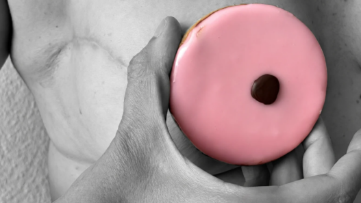 Carac rose tenu devant un torse en noir et blanc, illustration de sensibilisation au cancer du sein pour Octobre Rose.