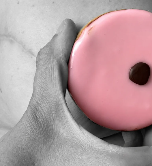 Carac rose tenu devant un torse en noir et blanc, illustration de sensibilisation au cancer du sein pour Octobre Rose.