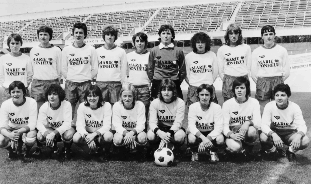 Photo d’archive en noir et blanc de l’équipe féminine du Stade de Reims posant dans un stade
