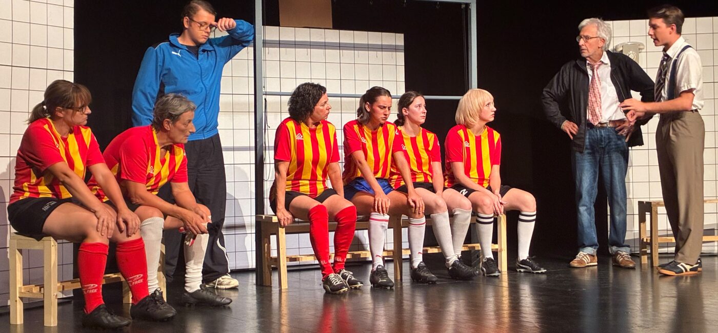 Scène de Féminines à Treyvaux avec les joueuses en maillots rouges et jaunes sur les bancs