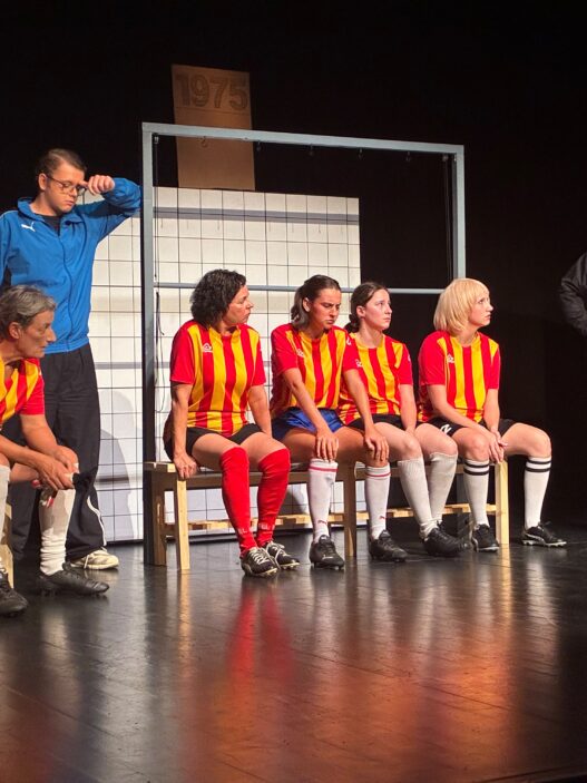Scène de Féminines à Treyvaux avec les joueuses en maillots rouges et jaunes sur les bancs