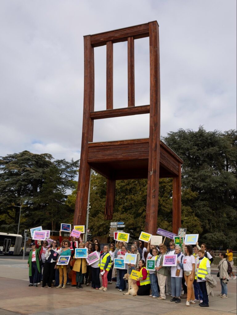 Participantes et participants à la mobilisation World with Women du 13 octobre 2026 devant la Broken Chair à Genève.